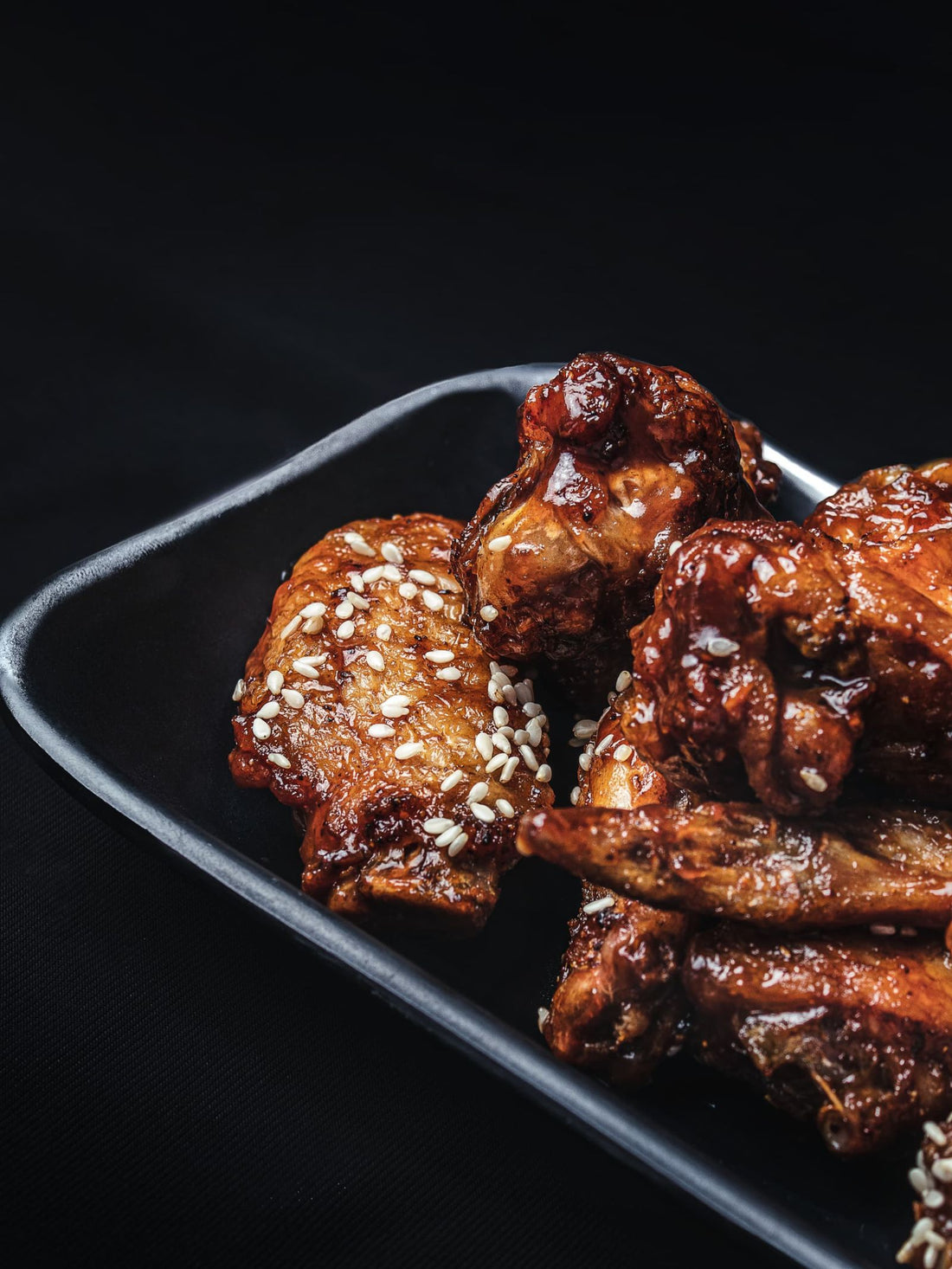 Sweet and spicy glazed quail wings with sesame seeds