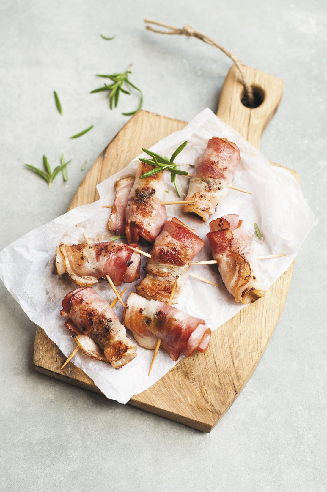 Bacon-wrapped quail bites appetizer on a wooden board